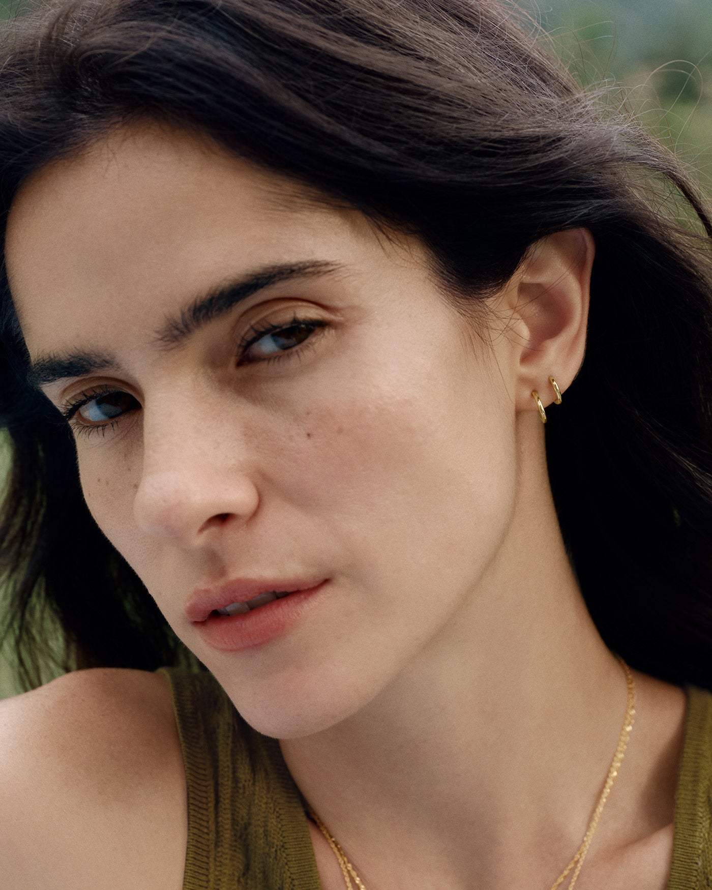 Gold Smooth Huggie Hoop Earrings worn on the ear